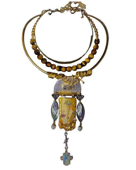 Ornate necklace with yellow beads and a central pendant on a black background